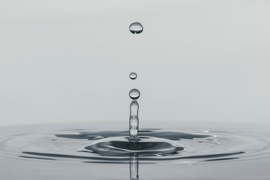 a drop of water falling into a body of water